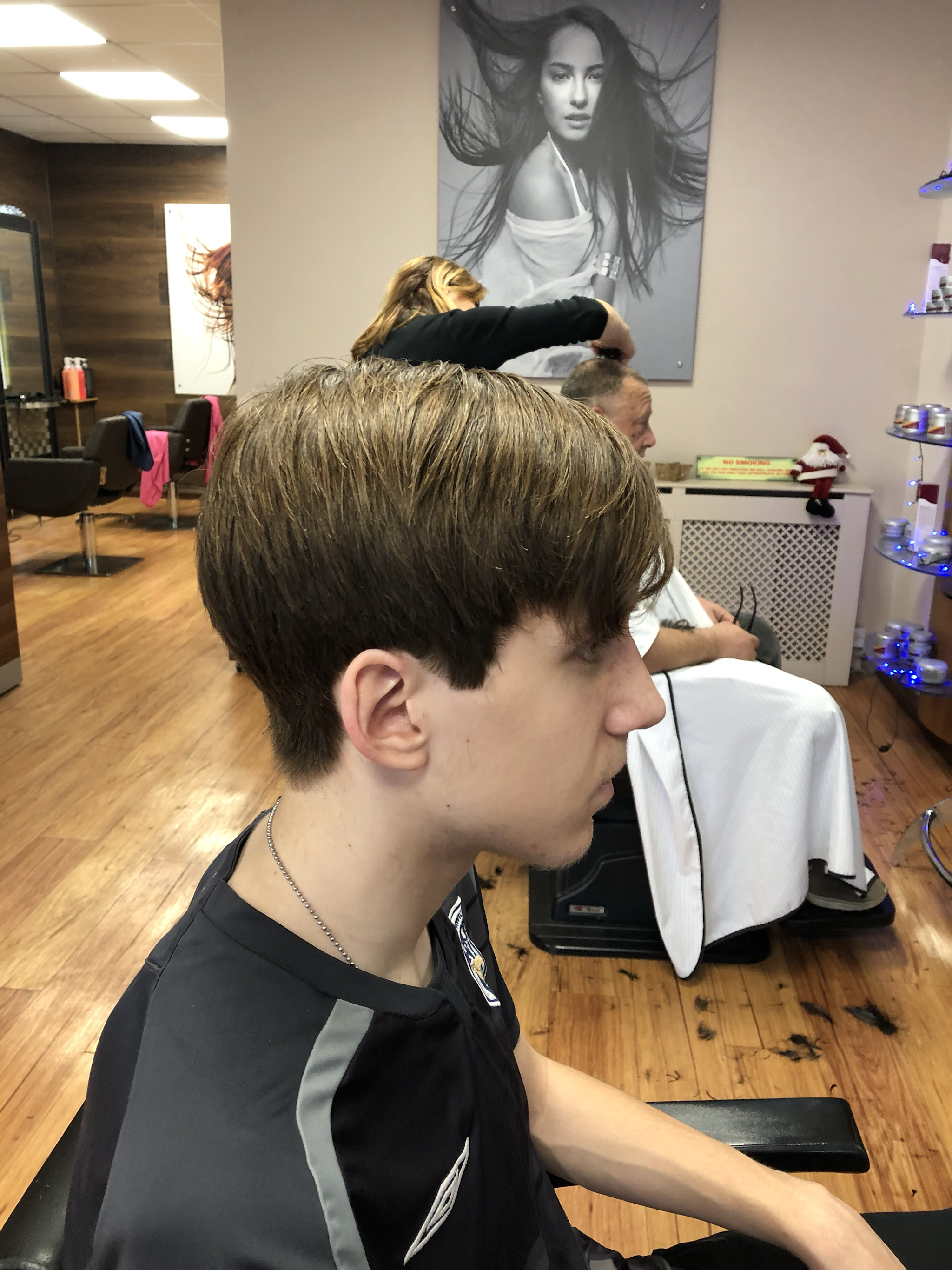 A finished short haircut, seen from the side, in the shop