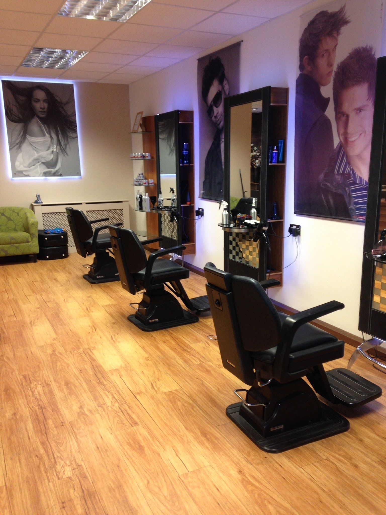 Inside The Ludgershall Barber Shop: barber chairs and mirrors along a wood floor