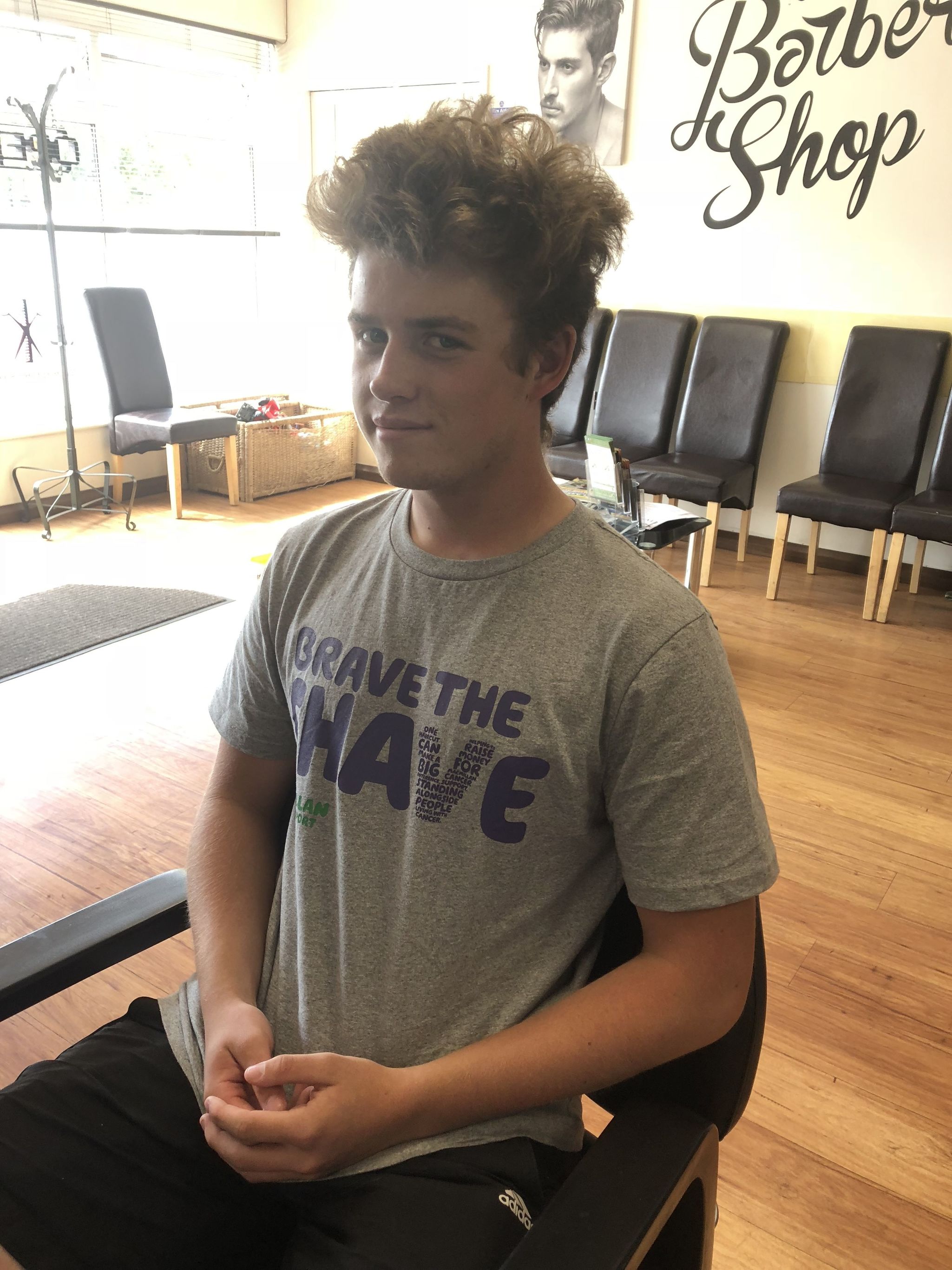 A young man in a Brave the Shave t-shirt before his shave
